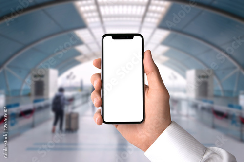 Centered  closeup of hand holding blank screen smartphone in train station terminal