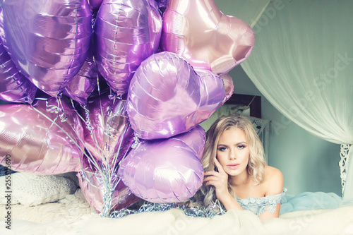 Beautiful romantic blonde woman with pink bolloons dreaming in bedroom photo