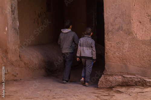 The boys play the ball in a narrow street of a traditional Berber town. Africa Morocco Ouarzazate