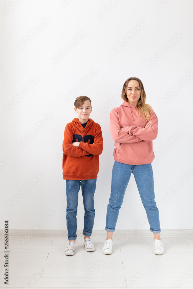 Mothers day, children and family concept - teen boy and his mom posing on white background Mothers day, children and family concept - teen boy and his mom posing on white background
