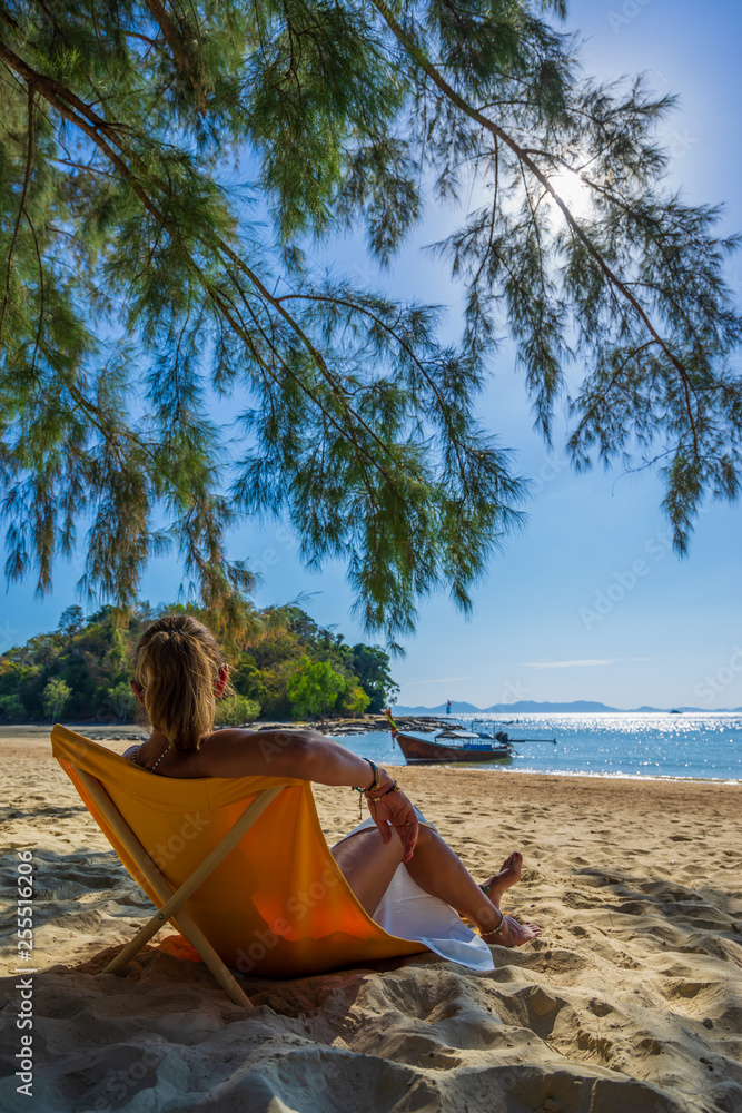 Woman enjoying her holidays on a transat at the tropical beach Woman enjoying her holidays on a transat at the tropical beach