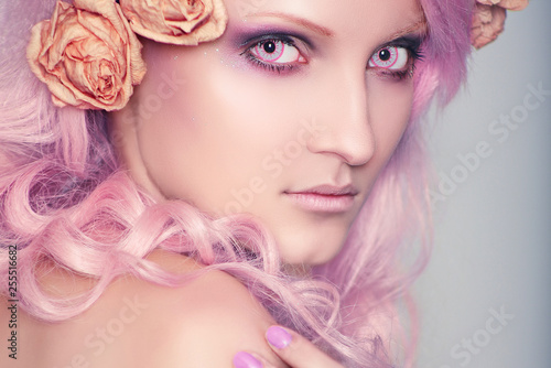 Beautiful and young girl with pink hair in coloured crazy contact lenses