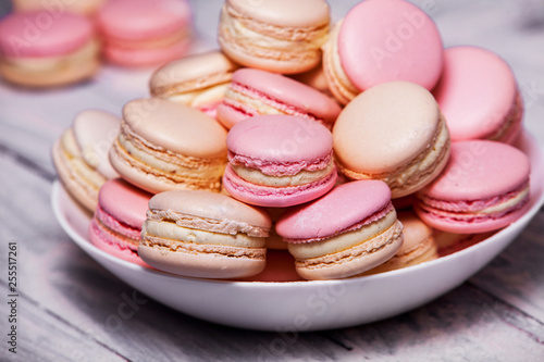 Macaron cookies in white bowl Sweet and colorful french macaroons Close up colorful macarons dessert with vintage pastel tones