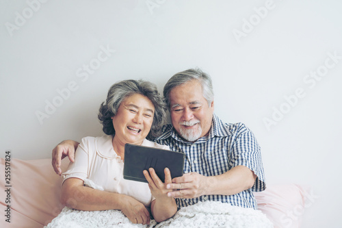 Murais de parede Senior couple using a tablet phone computer face time call to relatives descenda
