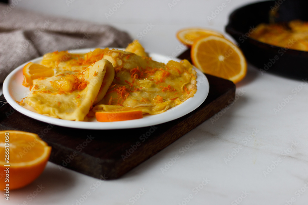 Traditional French crepes Suzette with orange sauce on white plate Traditional French crepes Suzette with orange sauce on white plate