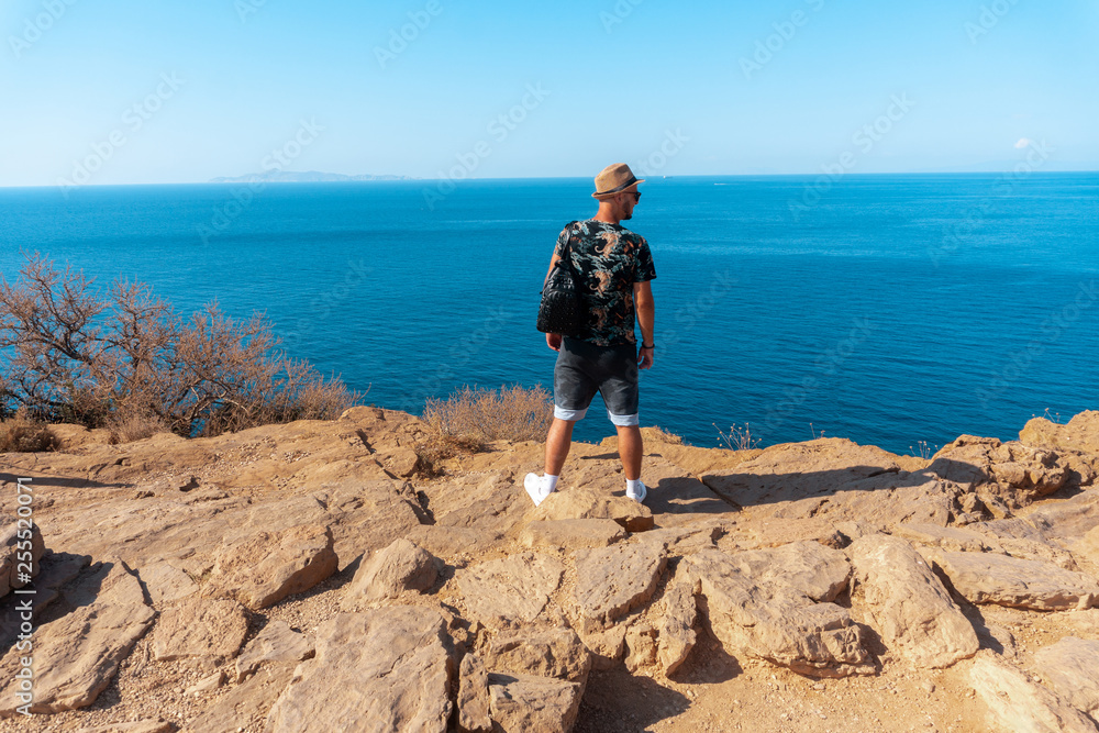 stylish man on the cliff by the sea