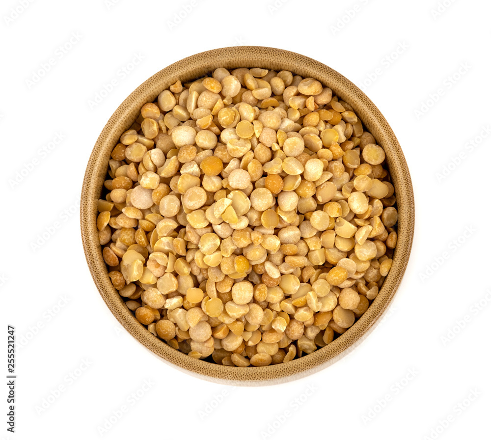 Raw yellow split peas in a wooden plate (bowl) isolated on white background, top down view Raw yellow split peas in a wooden plate (bowl) isolated on white background, top down view