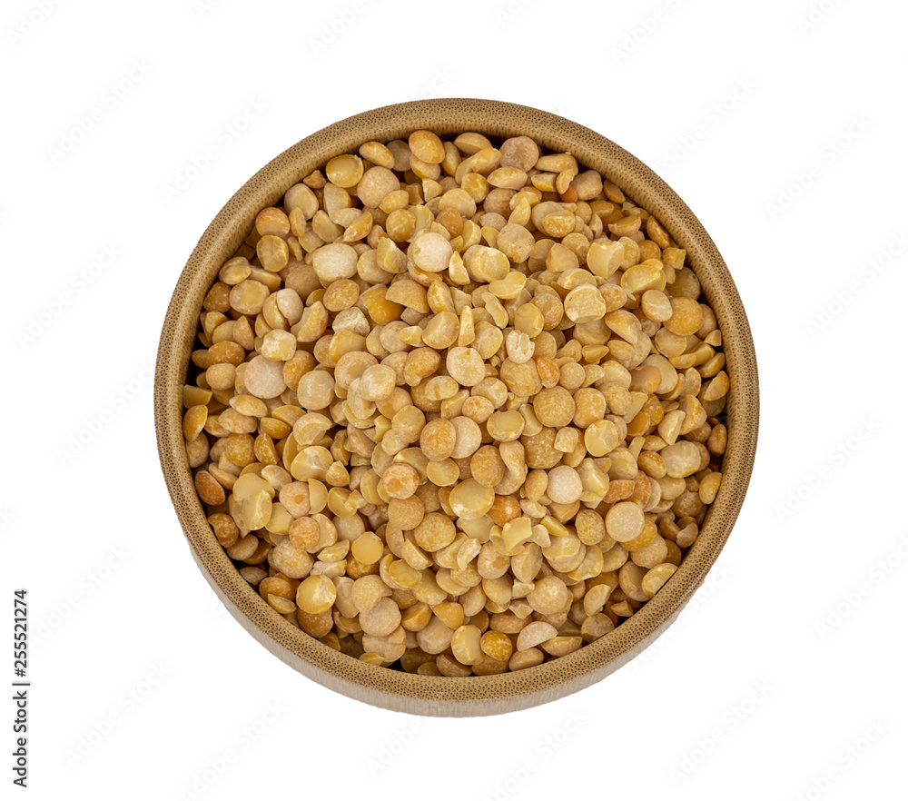 Raw yellow split peas in a wooden plate (bowl) isolated on white background, top down view Raw yellow split peas in a wooden plate (bowl) isolated on white background, top down view