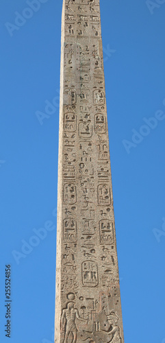 Egyptian obelisk with hieroglyphics and blue sky background