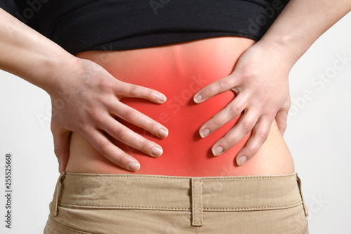 Wallpaper Mural A woman holds her hand with a painful back. on grey Torontodigital.ca