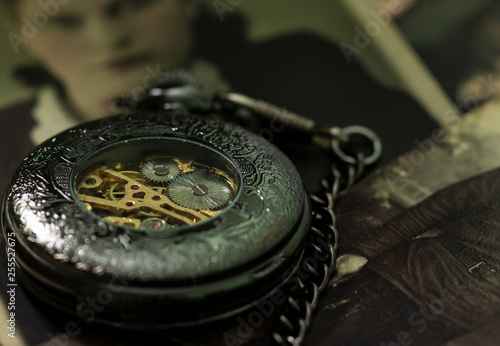 Pocket vintage watch on the background of old photos.
