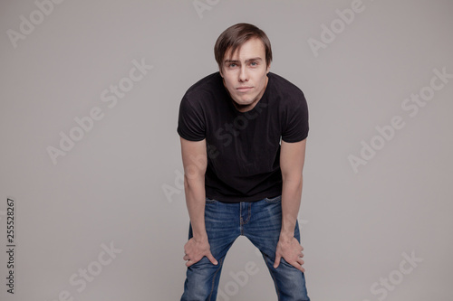 White young man in a black T-shirt and jeans. Emotion.