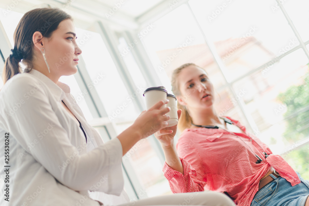 Two beautiful women sit talking. In the concept of relaxation. Two beautiful women sit talking. In the concept of relaxation.