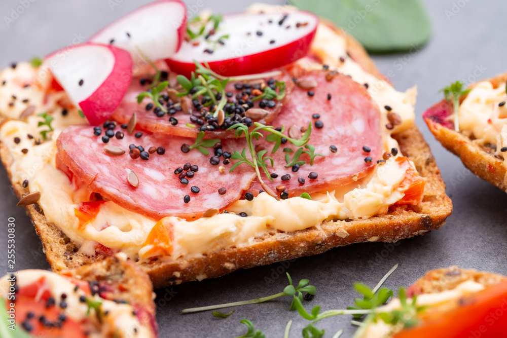 Sandwiches with cream cheese, vegetables and salami.