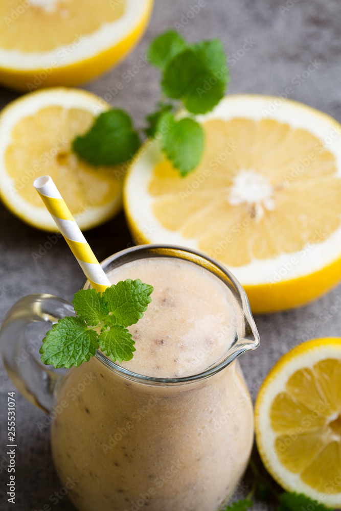 Banana and lemon smoothie, on the grey background. Banana and lemon smoothie, on the grey background.