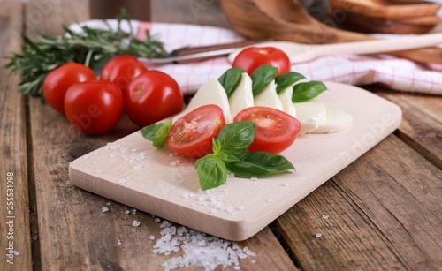 tomato mozzarella - fresh tomatoes with mozzarella cheese and basil on a rustic wooden table - healthy breakfast 
