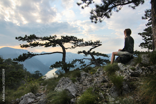 Freedom traveler woman sitting on the top of Tara Canyon enjoying the beautiful landscape.