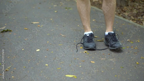 Man Noticing Shoe Laces Are Undone and Binds Shoes