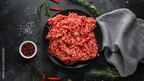 Fresh Raw mince, Minced beef, ground meat with herbs and spices on black plate