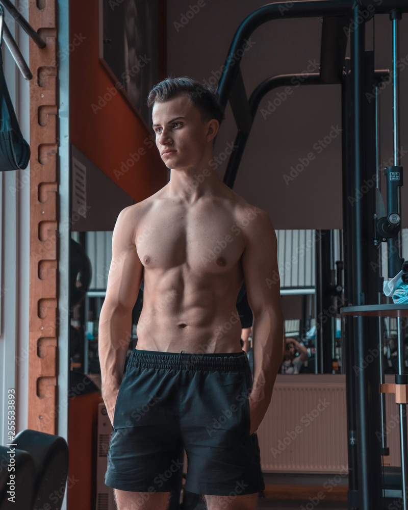 A portrait of a young strength athlete in a gym. Defined athlete with large muscles. Sports, sports, training, gym clothing. A portrait of a young strength athlete in a gym. Defined athlete with large muscles. Sports, sports, training, gym clothing.