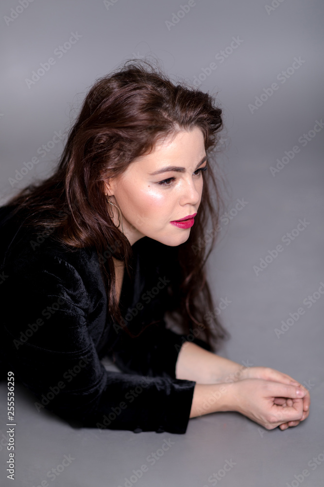 Beautiful elegant sexy brunette diva woman portrait in black clothes on grey background Beautiful elegant sexy brunette diva woman portrait in black clothes on grey background