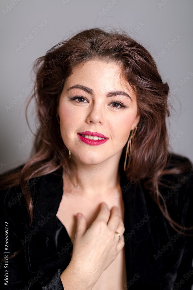 Beautiful elegant sexy brunette diva woman portrait in black clothes on grey background Beautiful elegant sexy brunette diva woman portrait in black clothes on grey background