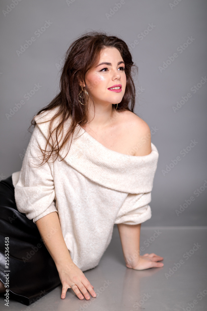 Beautiful elegant sexy brunette woman in a white sweater in the studio dreams of life Beautiful elegant sexy brunette woman in a white sweater in the studio dreams of life