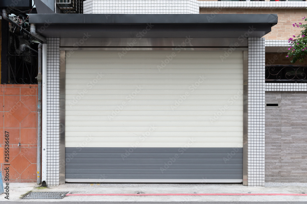 A closeup shot of automatic metal roller door used in factory, storage, garage, and industrial warehouse. The corrugated and foldable metal sheet offer space saving and provide urban and rustic feel A closeup shot of automatic metal roller door used in factory, storage, garage, and industrial warehouse. The corrugated and foldable metal sheet offer space saving and provide urban and rustic feel