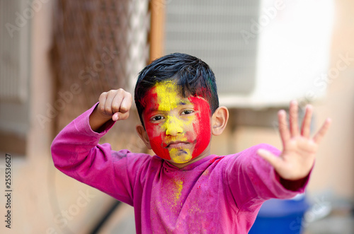Canvas Print Cute Little Indian boy child with coloured face during holi indian festival look