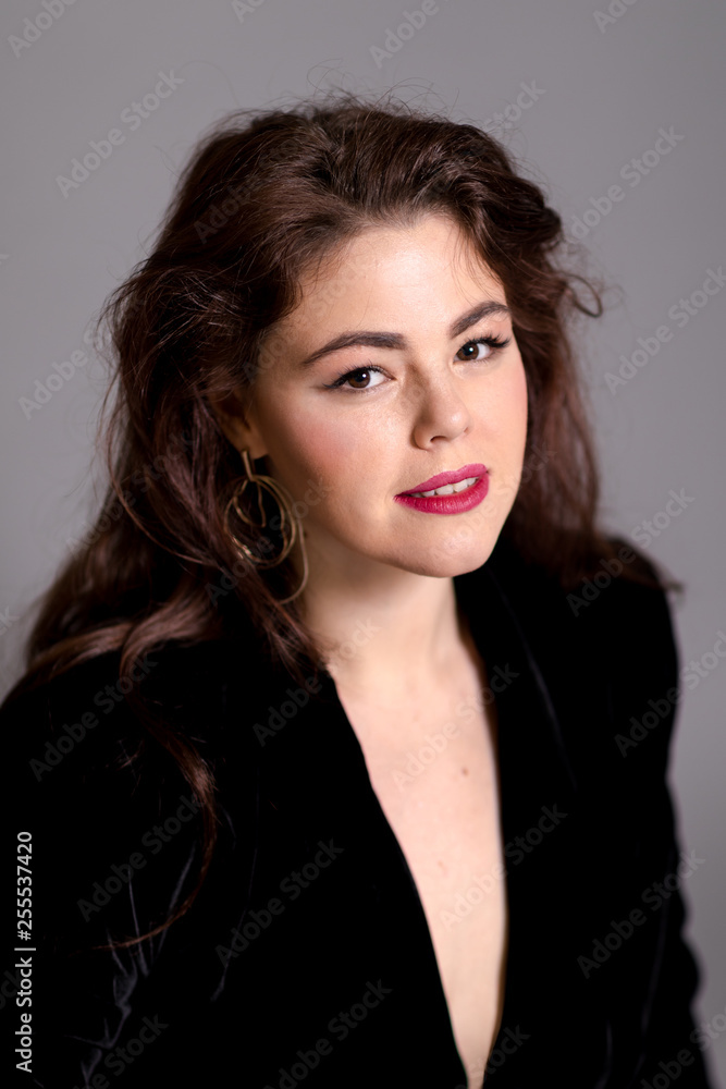 Beautiful elegant sexy brunette diva woman portrait in black clothes on grey background Beautiful elegant sexy brunette diva woman portrait in black clothes on grey background
