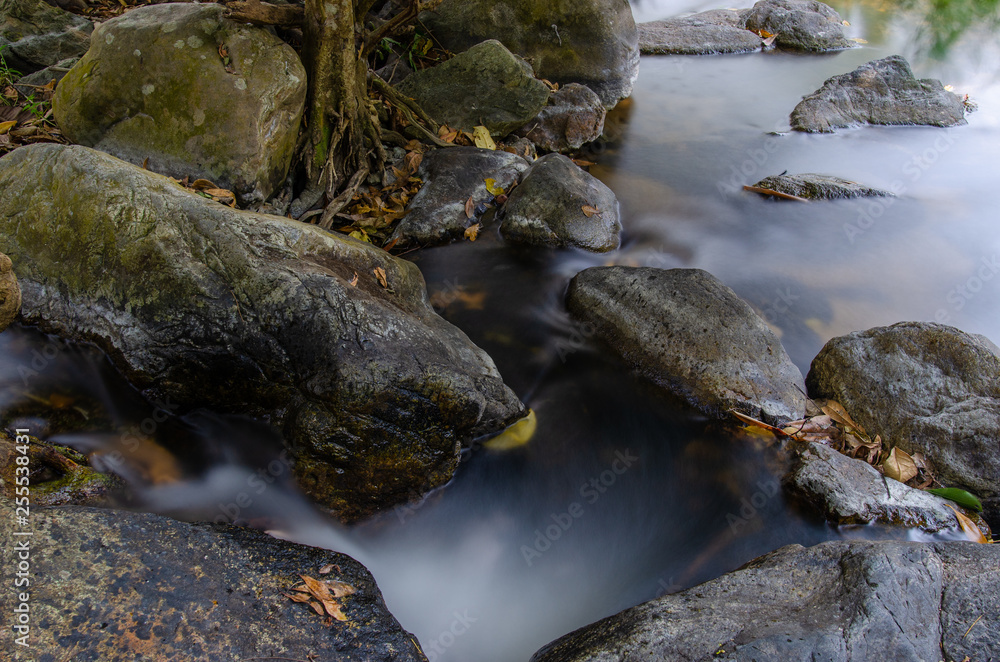 River flowing around the smooth rocks. Taken at Khlong Lan Waterfall Kamphaeng Phet Province, Thailand. River flowing around the smooth rocks. Taken at Khlong Lan Waterfall Kamphaeng Phet Province, Thailand.