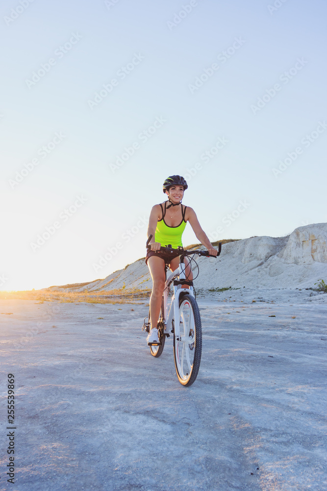 Fototapeta premium Young sporty woman with a bike, soft focus background