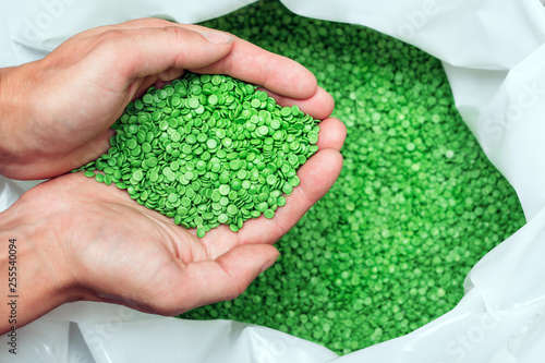 hands hold or touching biodegradable plastic pellets, plastic polymer granules photo