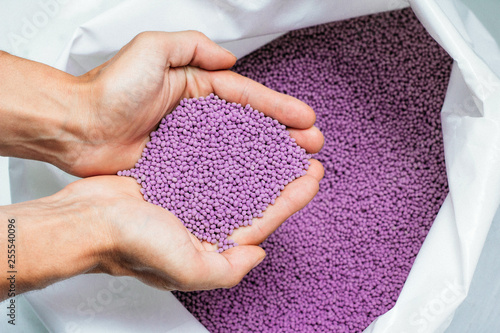Obraz na płótnie hands hold or touching biodegradable plastic pellets, plastic polymer granules