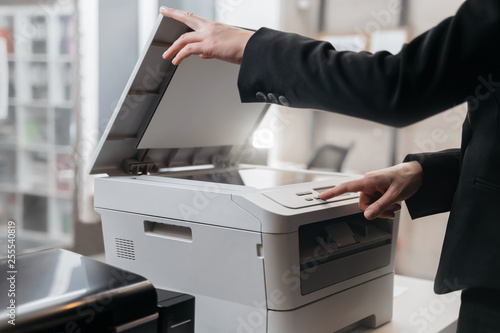 Business woman is using the printer to scanning and printing document photo