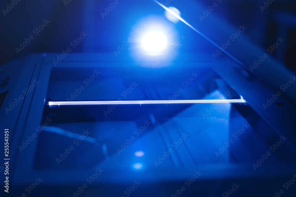 Copier scanner with a bright light inside. Office hazards concept