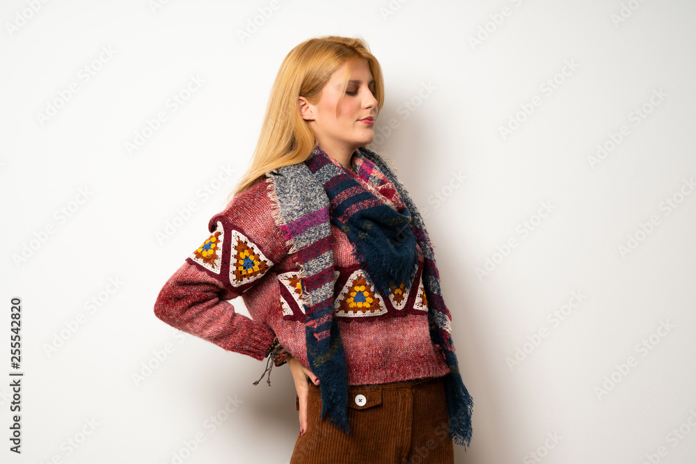 Hippie woman over white wall suffering from backache for having made an effort Hippie woman over white wall suffering from backache for having made an effort
