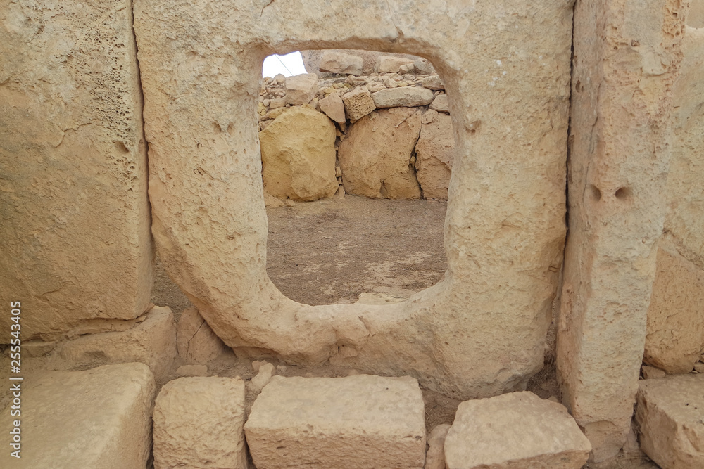 Window view of ancient limestone structures of Hagar Qim and Gnajdra Temples in Qrendi, Malta