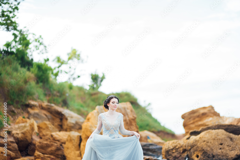 bride in a blue light dress walking along the ocean bride in a blue light dress walking along the ocean