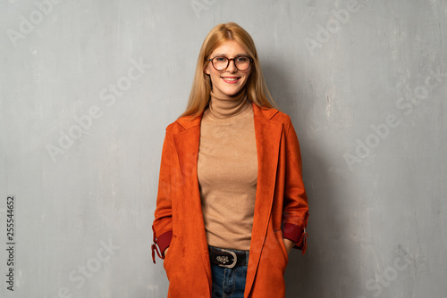 Woman over textured background with glasses and happy © luismolinero