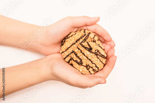 In the hands of a young girl lies biscuits with nuts and chocolate, a healthy snack