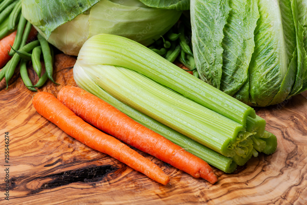 A variety of fresh raw Organic Vegetables including Celery Stalk, Carrots, Cabbage.