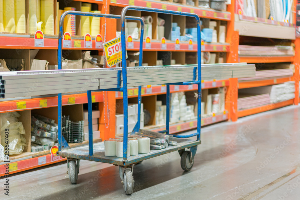 construction cart in the building store. Carts loaded with boards. shop of building materials. Racks with boards, wood and building material. loaded cart in a hardware store