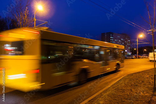 The motion of a blurred bus the street in the evening.