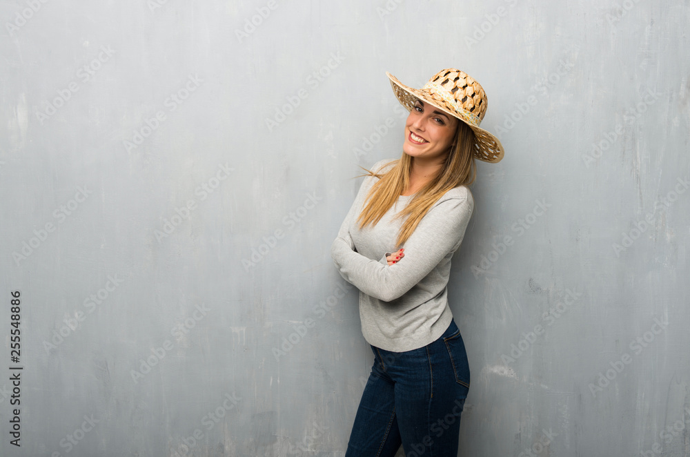 Young woman on textured wall with hat Young woman on textured wall with hat
