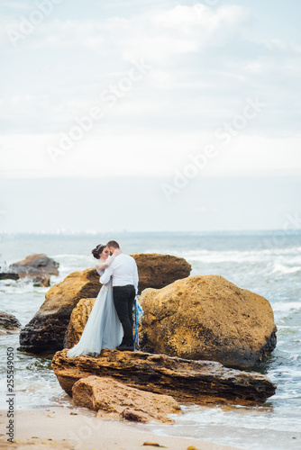 same couple with a bride in a blue dress walk