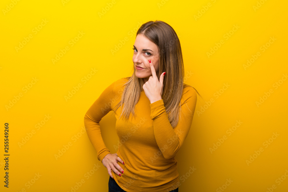 Young woman on yellow background looking to the front Young woman on yellow background looking to the front