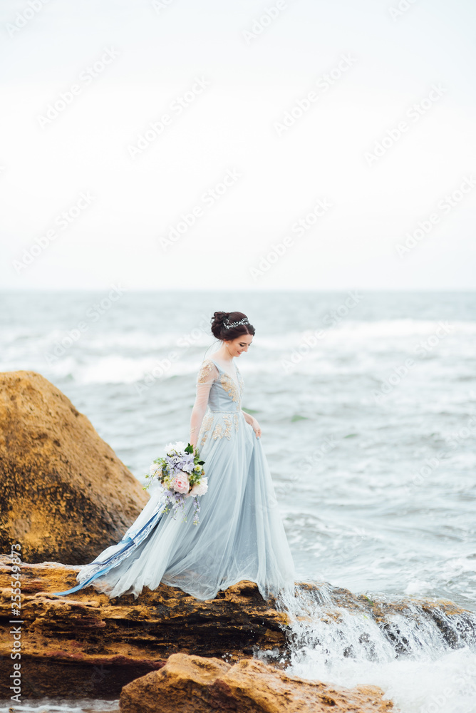 bride with a bouquet of flowers on the beach