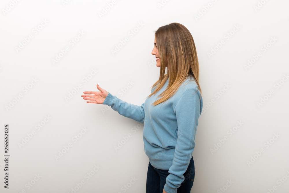 Blonde woman on isolated white background handshaking after good deal Blonde woman on isolated white background handshaking after good deal