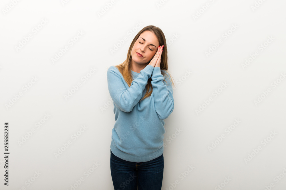 Blonde woman on isolated white background making sleep gesture in dorable expression Blonde woman on isolated white background making sleep gesture in dorable expression